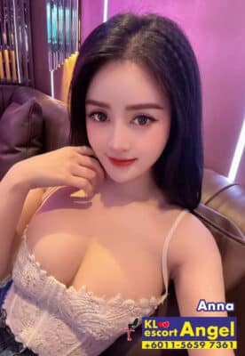 Sexy Malaysian KL escort model in lace top and jeans sitting on sofa