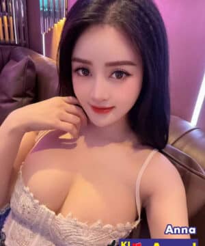 Sexy Malaysian KL escort model in lace top and jeans sitting on sofa